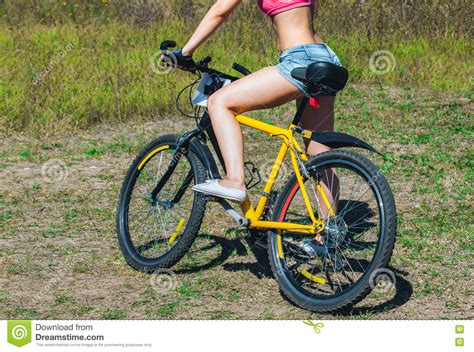 Girl Athlete In Jeans Short Shorts Riding A Bike Stock