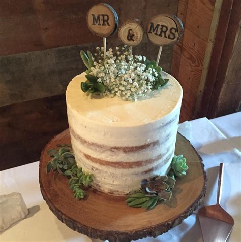 rustic naked cake with succulents on a wooden cake stand wedding cake