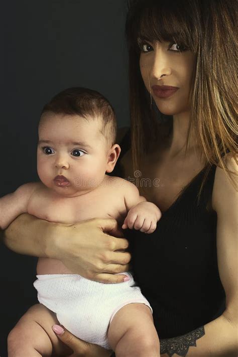 Belle Mère De Brune Tenant Son Bébé Utilisant Une Couche Culotte Photo