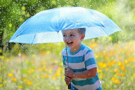 fotos junge lachen laecheln froehliches kind regen regenschirm