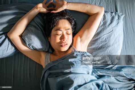 Young Japanese Woman Sleeping In A Bed In A Bedroom High Res Stock