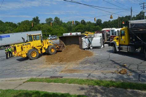 dump truck overturns loses load  dirt   street news