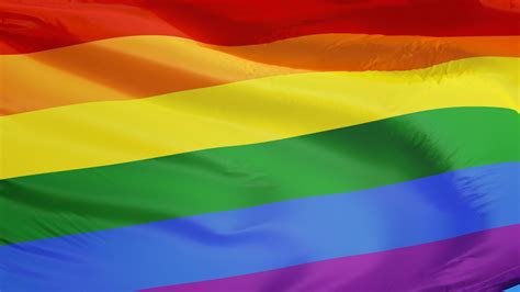 gay pride rainbow flag waving  clean blue sky close