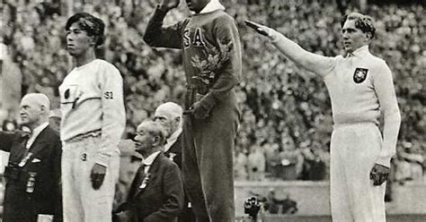 jesse owens on the podium after winning the long jump at