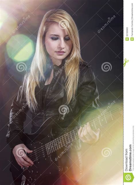 sexy junge blondine kleidete im schwarzen leder an das elektrisches gui spielt stockfotos