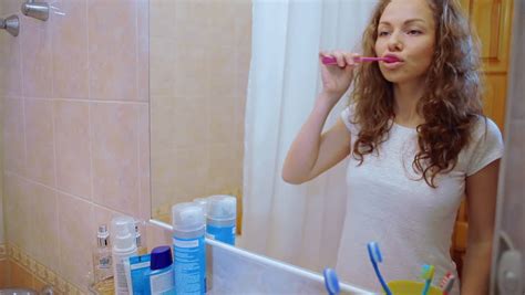 beautiful girl brushing teeth in the morning she takes a brush