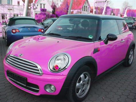 pink mini car parked  front   cars