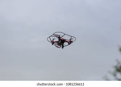 small red camera drone hovers high stock photo edit