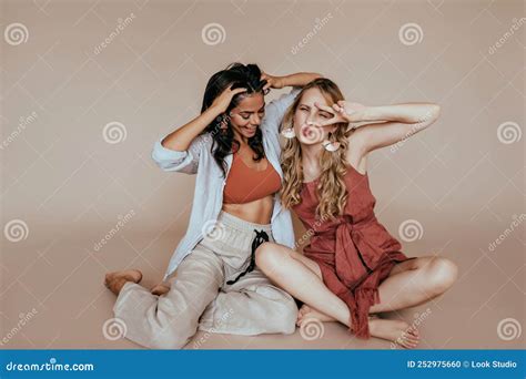 Gorgeous Blonde Girl Sitting With Legs Folded Near Friend Dreamy