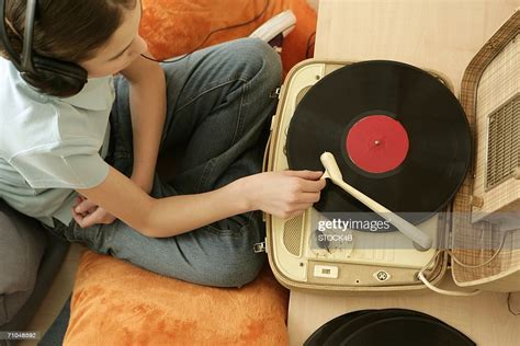 Girl Listening To Music Of A Record Player By Earphones