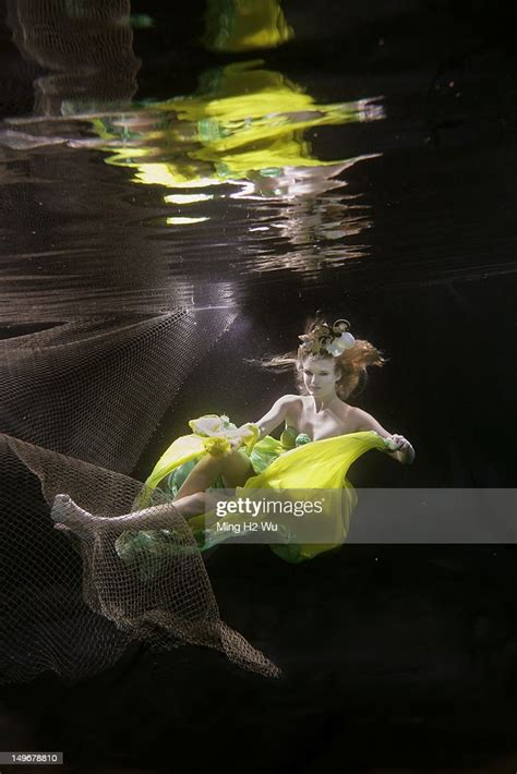 caucasian woman in dress swimming under water photo getty images