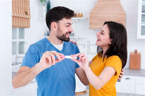 happy couple showing off pregnancy test stock image colourbox