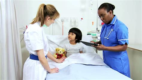 little south asian girl receiving special pediatric care from dedicated female nurses using