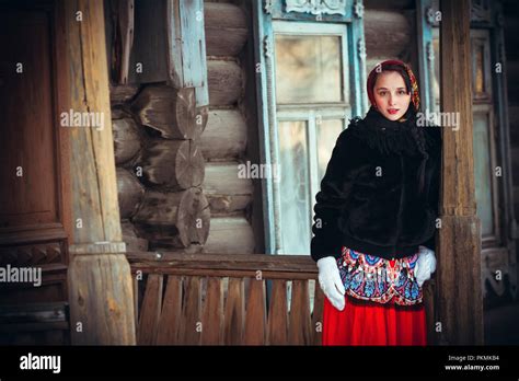 russian girl in the winter in the village near the old house beautiful
