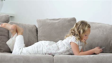 Lovely Girl Lying On The Sofa With A Tablet Pc Stock Video Footage 00