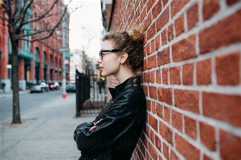 Profile Of A Beautiful Woman Leaning Against A Brick Wall In Nyc By