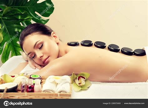 beautiful woman relaxing spa salon hot stones body massage