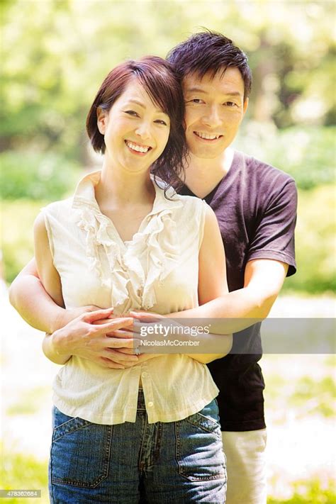 happy smiling healthy mature japanese couple embracing in tokyo park