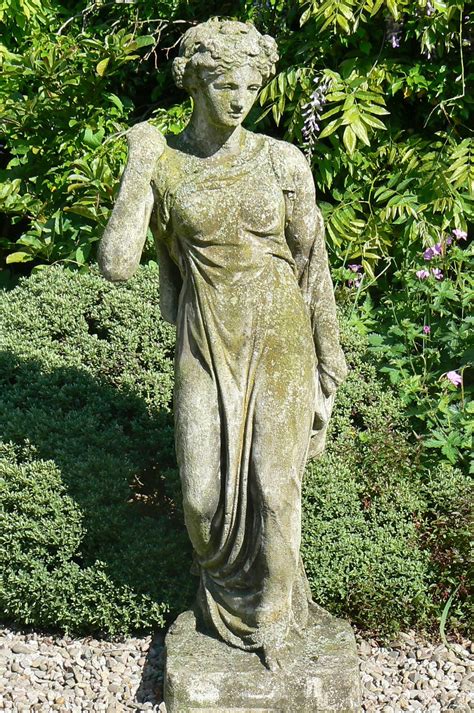 statue  standing   middle   bushes