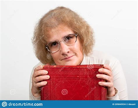 Happy Mature Woman With Glasses Holding Old Red Paperback Book Bible