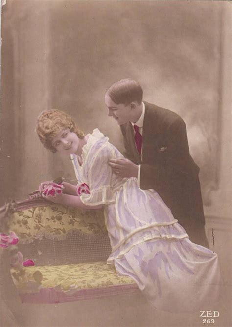 An Old Fashion Photo Of A Man And Woman Sitting On A Couch With Flowers