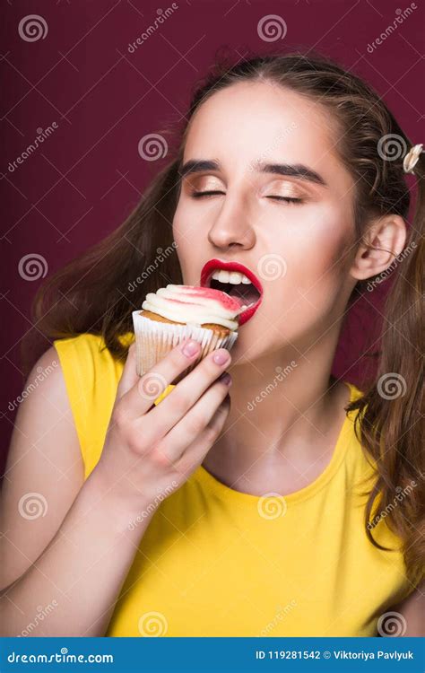 Hungry Brunette Model Biting Yummy Cake With Cream Over A Red Ba Stock