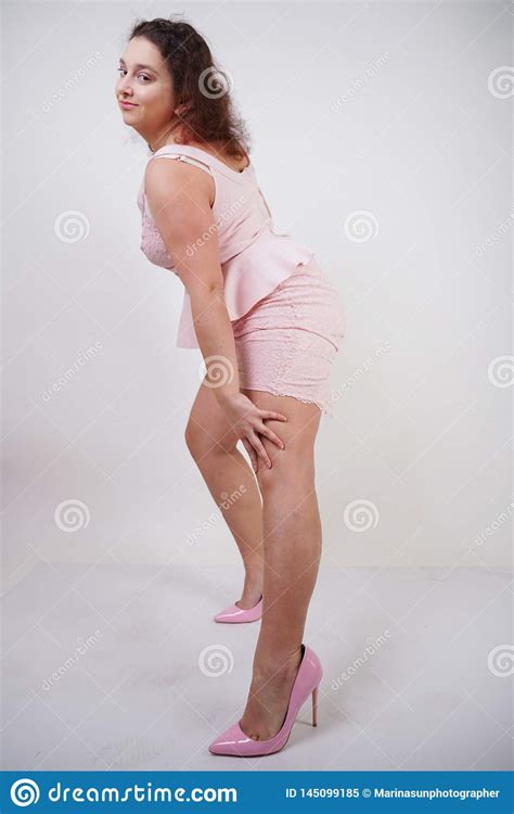 Pretty Chubby Positive Girl Dancing In Pink Fashionable Dress On White