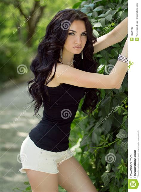 beautiful slim brunette model woman posing on nature background stock