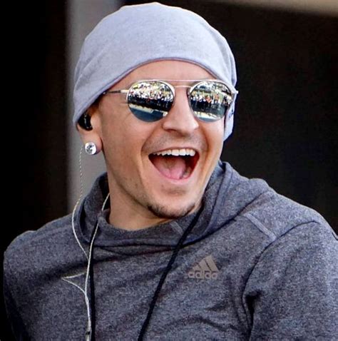 man  sunglasses  headphones  smiling   camera  wearing earbuds