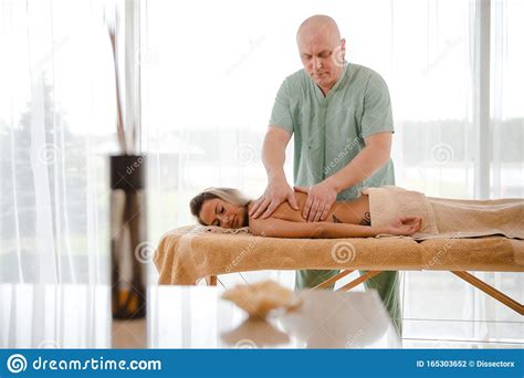 Blonde Woman Relaxing Receiving Back Massage From Male Physiotherapist