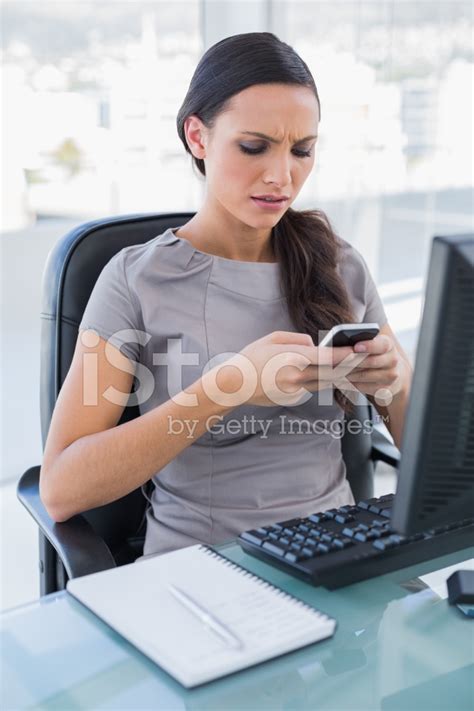 rynkar pannan vacker affärskvinna textning på sin smartphone stockfoton
