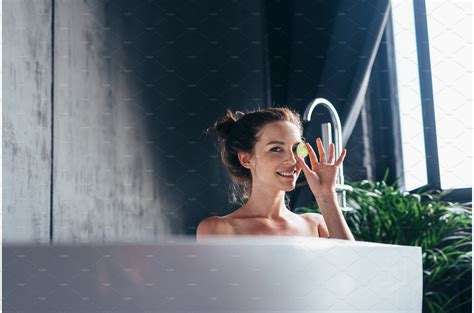 woman sits in the bathtub and holds people images ~ creative market