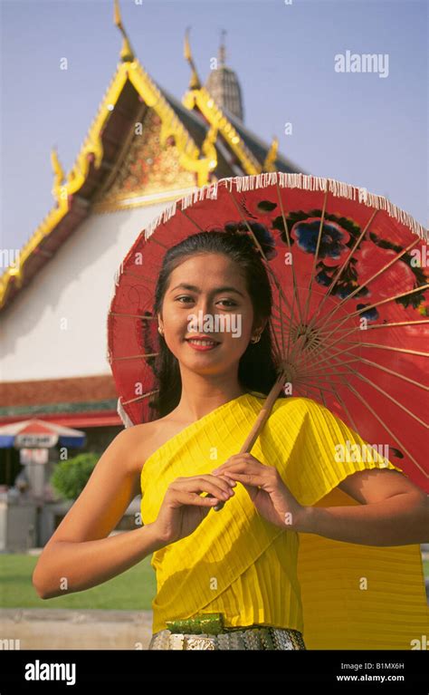 A Beautiful Young Thai Girl Wearing Traditional Siamese Clothing At The Wat Arun Temple In