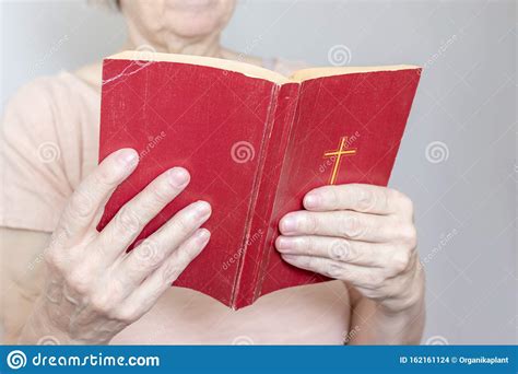 Senior Woman Holding An Old Holy Bible In Hands Elder
