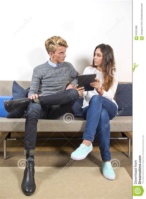 Man And Woman On A Sofa Surfing Online Together Stock