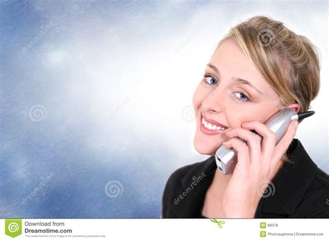 mooie vrouw op de draadloze telefoon van het huis tegen blauwe achtergrond stock foto image