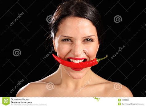 beautiful woman biting on red chili pepper stock image