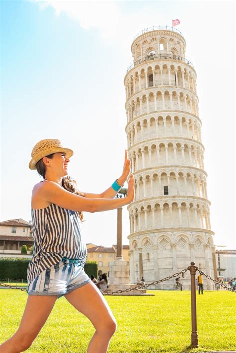 funny young woman supporting leaning tower  pisa tuscany italy cheaptickets travel deals