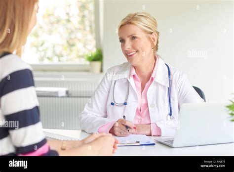 Female Doctor Sitting At Doctors Office With Her Patient And