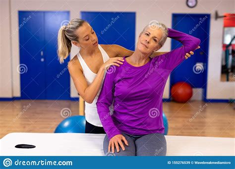 Female Physiotherapist Giving Arm Massage To Active Senior Woman In