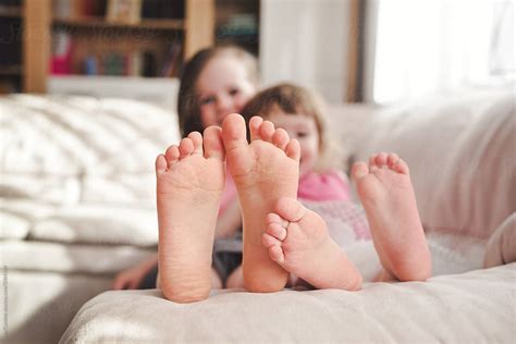 siblings having fun and showing their feet by stocksy contributor
