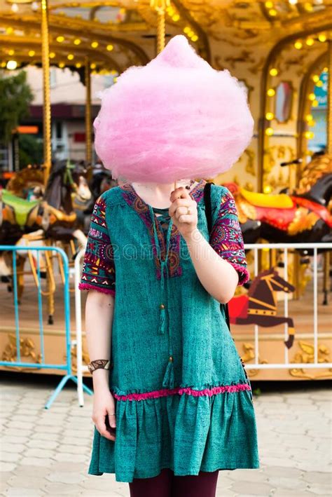 Young Beautiful Hipster Woman Eating Cotton Candy In An Amusement Park