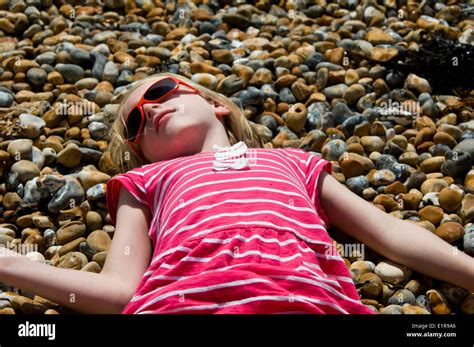 young girl sunbathing   pebble beach stock photo alamy