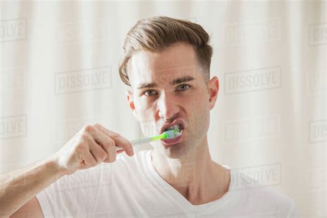 caucasian man brushing  teeth stock photo dissolve