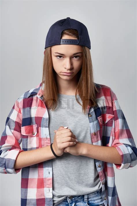 angry teen girl wearing checkered shirt and baseball cap