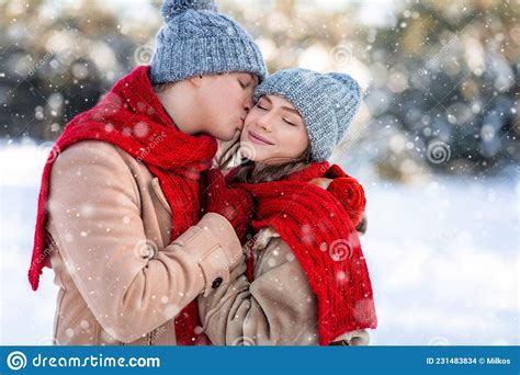 Loving Man Kissing His Pretty Girlfriend While Enjoyng Snowy Weekend