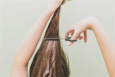 een jong meisje besliste haar haar te snijden  de handen van het houden van een bos van haar