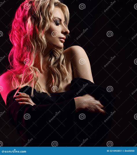 portrait of sensual blonde woman with her head turned taking off her