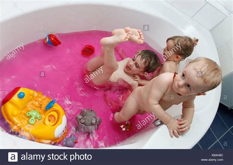 kinder spielen in der badewanne mit rosa wasser stockfoto bild