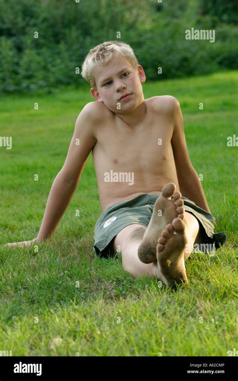 Porträt Von Barfuß Junge Mit Schmutzigen Füßen Sitzen In Der Wiese